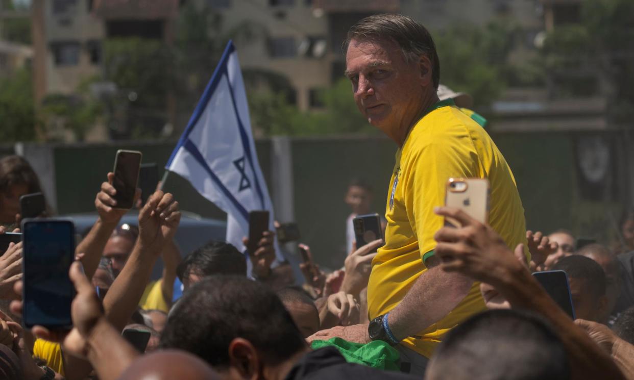 <span>Jair Bolsonaro is surrounded by supporters in Rio de Janeiro, Brazil on Saturday.</span><span>Photograph: Silvia Izquierdo/AP</span>