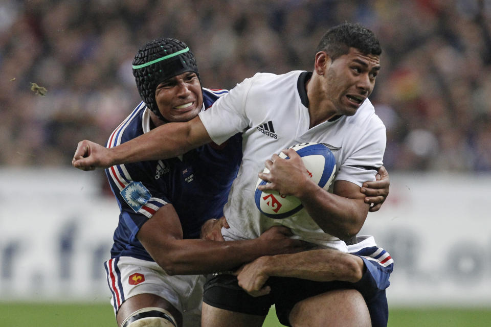 FILE - New Zealand All Blacks Charles Piutau is tackled by France's Thierry Dusautoir, during their international rugby, at the Stade de France stadium in Saint Denis, outside Paris, on Nov. 9, 2013. A loophole that has allowed rugby players to more easily switch allegiances is helping reshape a sport that has previously tended to tie representative players to one country for life. (AP Photo/Thibault Camus, File)