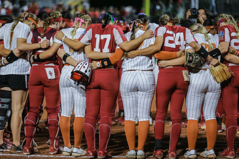 Texas and Oklahoma players pray together after Wednesday night's OU victory in Game 1 of the Women's College World Series at USA Softball Hall of Fame Stadium in Oklahoma City.