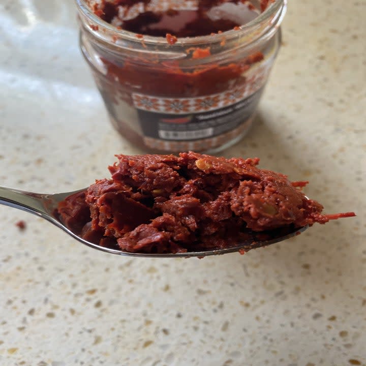 Spoonful of harissa from a glass jar