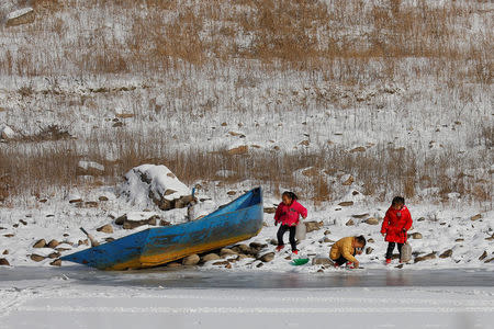 North Korean girls are photographed from the Chinese side of the border as they collect water from the frozen Yalu River near Linjiang, China, November 22, 2017. REUTERS/Damir Sagolj