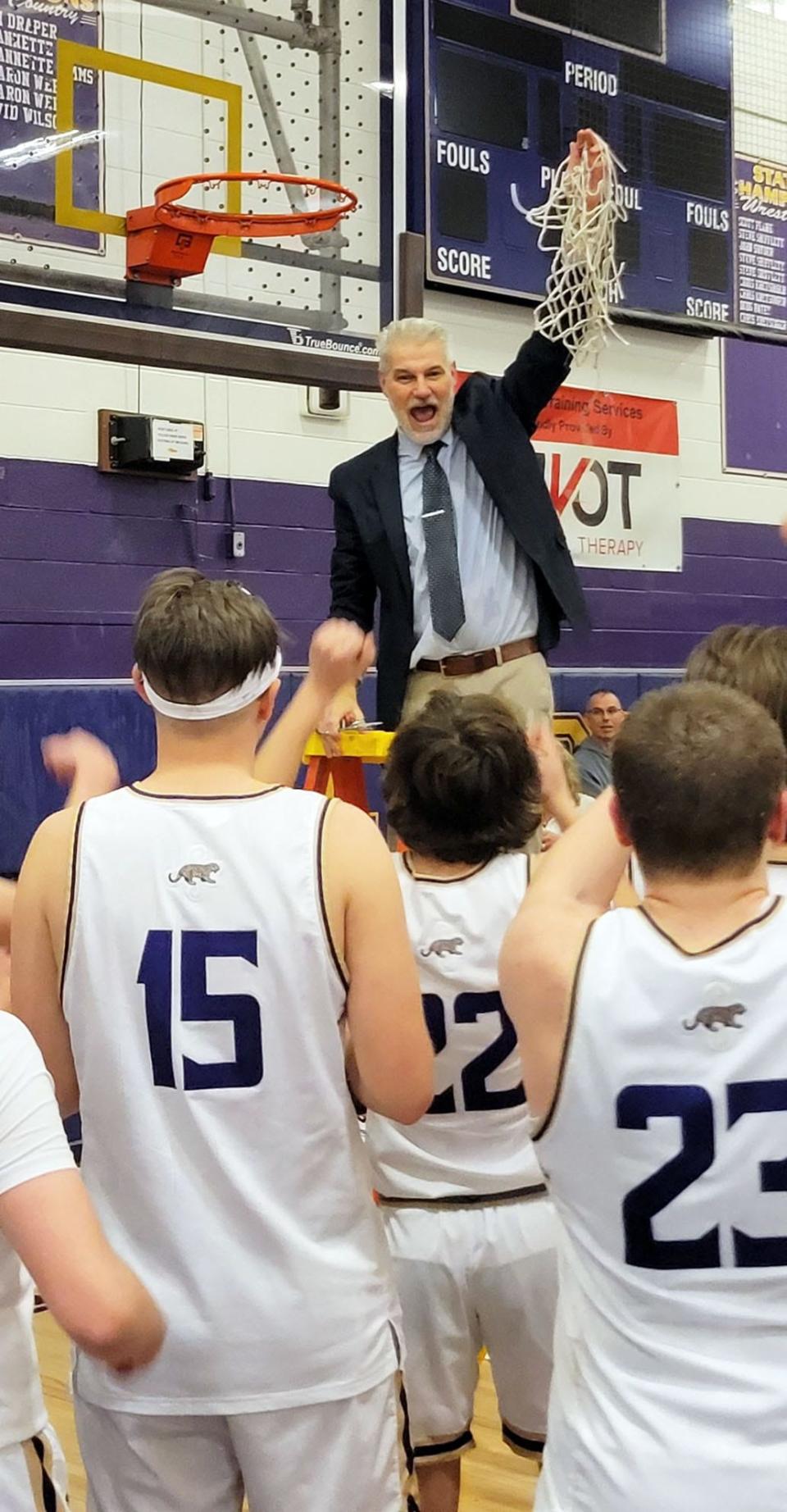 Smithsburg coach Eric Gerber celebrates after cutting down the final piece of the net following the Leopards' 41-40 win over Brunswick for the 1A West Region II title.