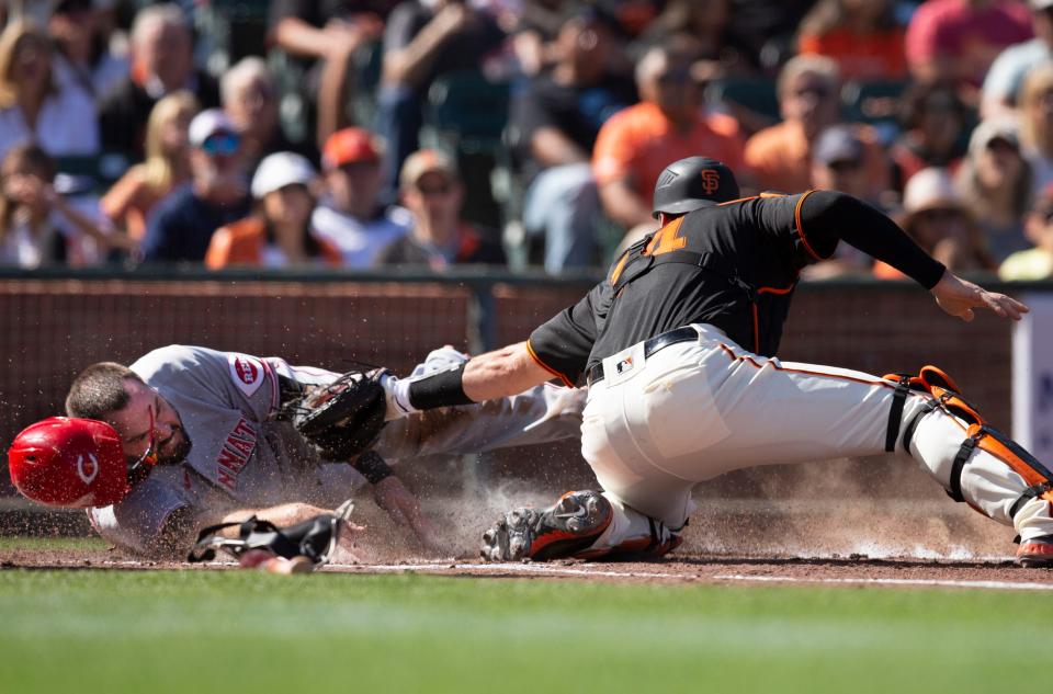 Jun 25, 2022; San Francisco, California, USA; Cincinnati Reds designated hitter Mike Moustakas (9) eludes the tag of San Francisco Giants catcher Austin Wynns (14) during the second inning at Oracle Park. Mandatory Credit: D. Ross Cameron-USA TODAY Sports