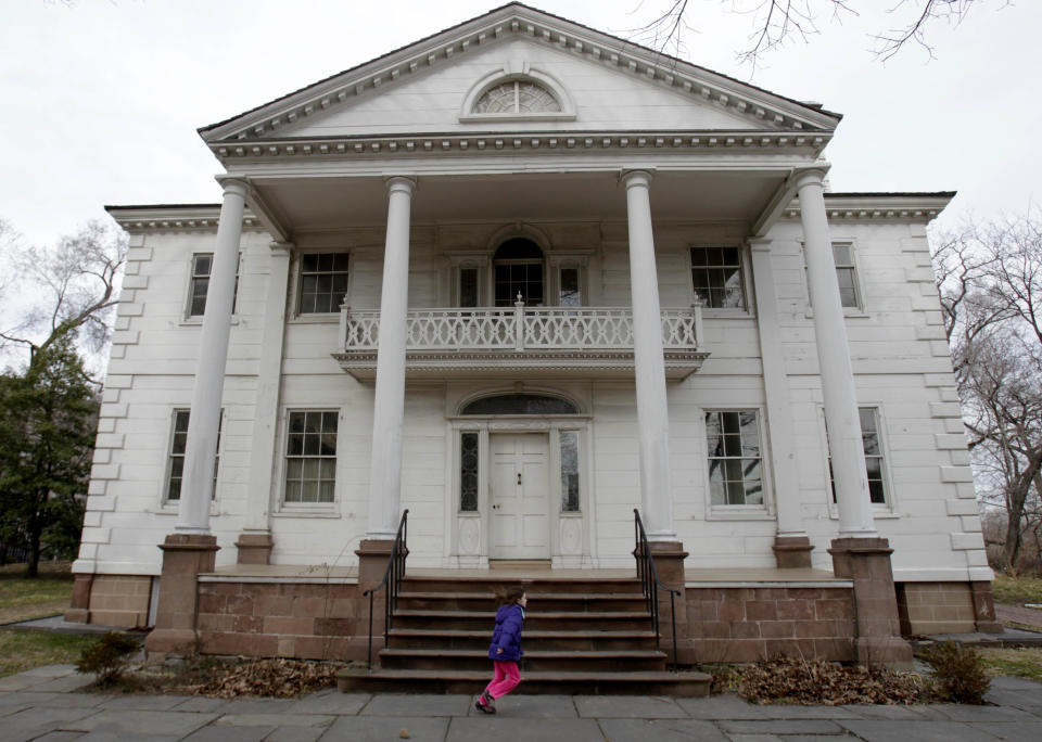 A girl runs around the Morris-Jumel Mansion, once home to George Washington, in the Washington Heights section of New York, Tuesday, Feb. 21, 2012. (AP Photo/Seth Wenig)