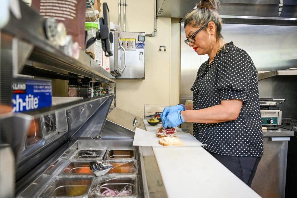 Faviola Avelar, owner of Downtown Oak, prepares a sandwich at the shop on the corner of Kern and L streets in downtown Fresno on Thursday, April 13, 2023. Avelar called the shop Downtown Oak for her love of oak trees.