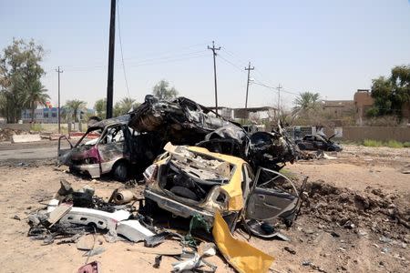 Destroyed vehicles are seen at the site of a suicide car bomber in Khalis, north of Baghdad, Iraq, July 25, 2016. REUTERS/Stringer