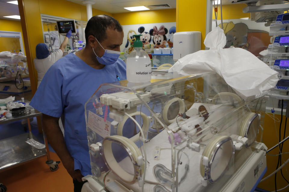 Paediatrician Dr. Msayif Khali watches one of the nine babies protected in an incubator at the maternity unit of the Ain Borja clinic in Casablanca, Morocco, Thursday May 20, 2021, two weeks after Mali's Halima Cisse, 25, gave birth to nine healthy babies. (AP Photo / Abdeljalil Bounhar)