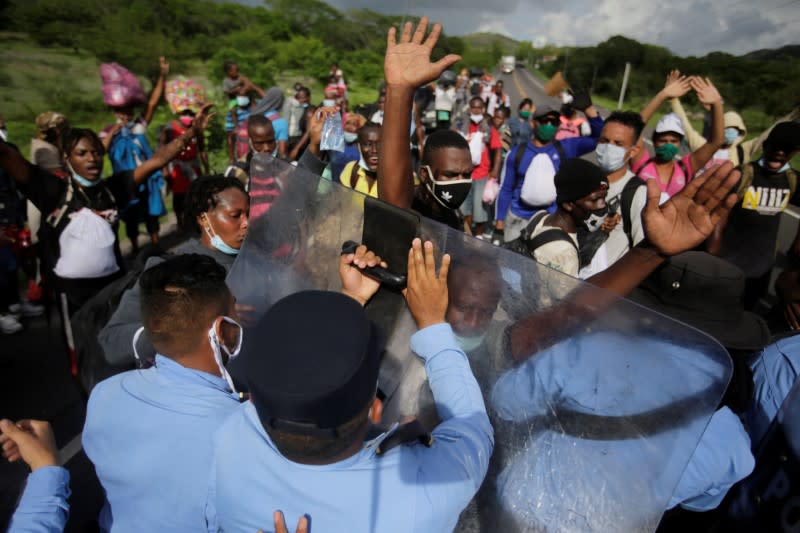 Migrants from Africa, Cuba and Haiti, who are stranded in Honduras after borders were closed due to the coronavirus disease (COVID-19) pandemic, scuffle with police officers while trekking northward in an attempt to reach the U.S., in Choluteca