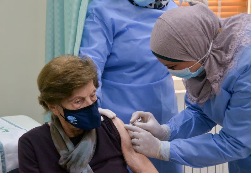 A woman receives the COVID-19 vaccine, at a medical center in Amman