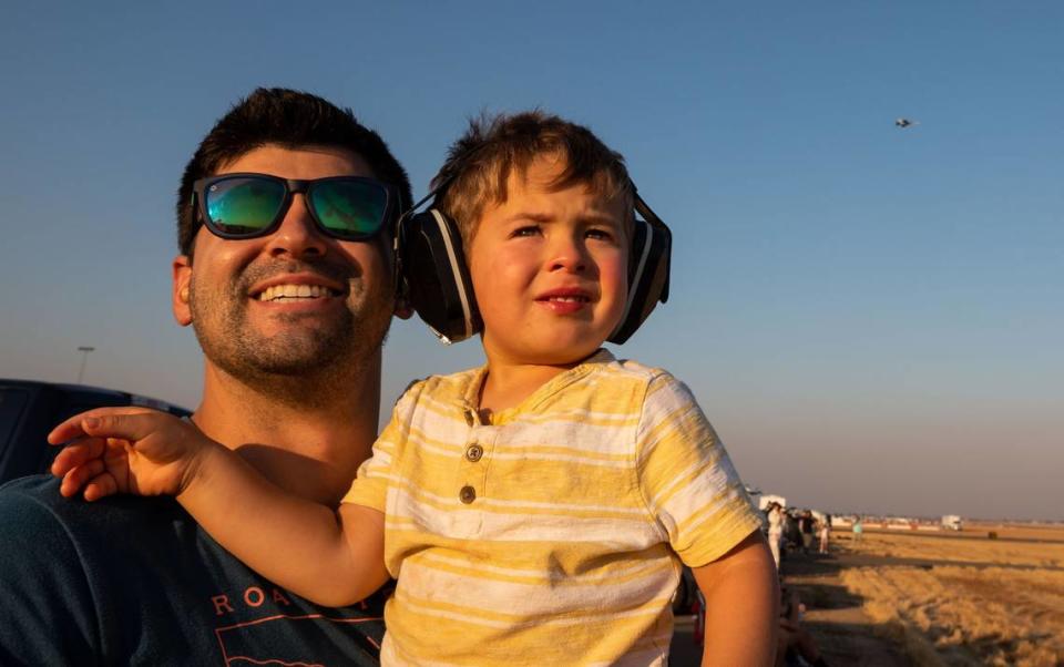 Roseville’s William Weisman, left, holds his son, Jonathan Weisman, 2, to watch a an incoming plane prepare to cross another during the California Capital Airshow’s Afterburnin’ Drive-In Airshow on Friday, Sept. 24, 2021, at Mather Airport in Sacramento. The drive-in event, which offered more personal space and opportunity to bring food and drinks from home, was a first of its kind for the airshow.