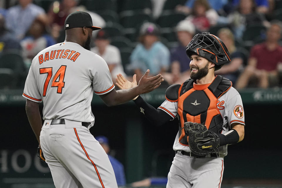 Baltimore Orioles closing pitcher Felix Bautista (74) is congratulated by catcher Anthony Bemboom after the final out of a baseball game against the Texas Rangers in Arlington, Texas, Monday, April 3, 2023. (AP Photo/LM Otero)