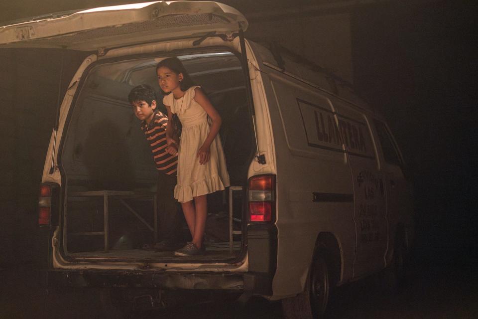 Miguel, played by Lucas Avila, and his sister Rocio, played by Cristal Aparicio, peer out from the back of a van after being abducted by human traffickers in a scene from "Sound of Freedom."