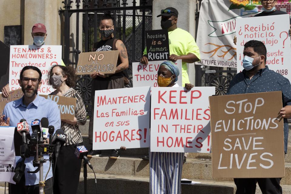 People from a coalition of housing justice groups hold signs protesting evictions during a news conference outside the Statehouse, Friday, July 30, 2021, in Boston. (AP Photo/Michael Dwyer)