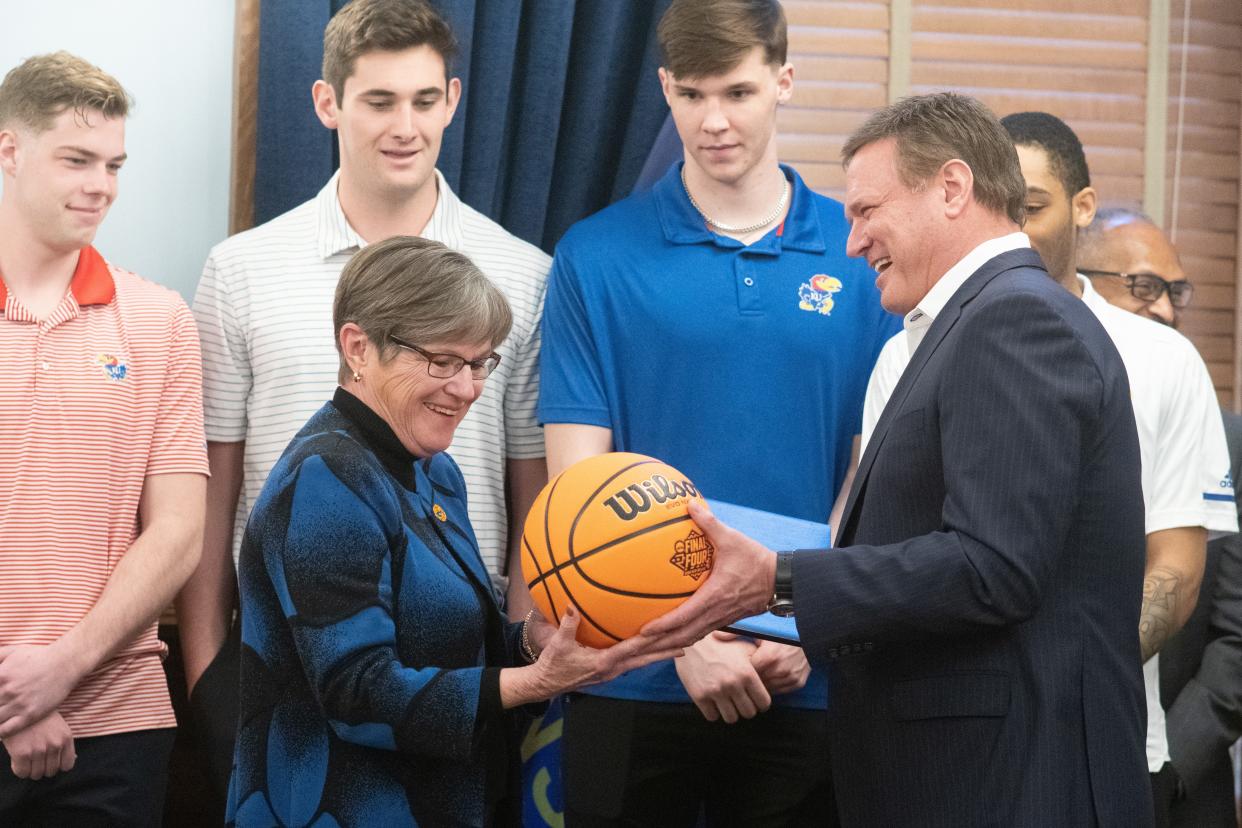 Gov. Laura Kelly receives a signed NCAA Final Four branded basketball signed by Kansas men's basketball coach Bill Self after signing and giving the head coach a signed proclamation Monday afternoon.