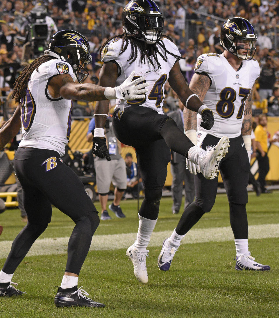 Baltimore Ravens running back Alex Collins, center, celebrates his touchdown in the first half of an NFL football game against the Pittsburgh Steelers in Pittsburgh, Sunday, Sept. 30, 2018. (AP Photo/Don Wright)