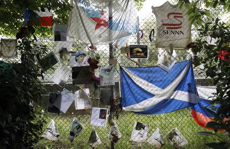 Handwritten notes and flags left by fans are pictured near the memorial statue of Brazilian Formula One driver Ayrton Senna at the race track in Imola April 22, 2014. REUTERS/Alessandro Garofalo