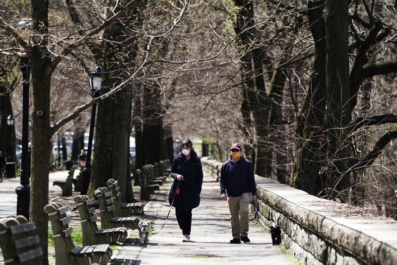 People walk their dogs while wearing protection masks during the outbreak of coronavirus disease (COVID-19), in the Manhattan borough of New York City