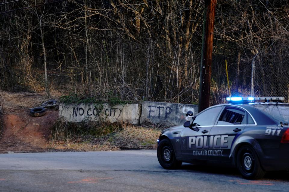 Law enforcement drive past the planned site of a police training facility