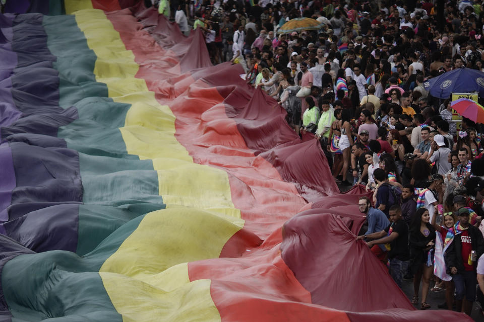 People carry a giant gay pride flag during during the annual pride parade along Copacabana beach in Rio de Janeiro, Brazil, Sunday, Sept. 22, 2019. The 24th gay pride parade titled this year's parade: "For democracy, freedom and rights, yesterday, today and forever." (AP Photo/Leo Correa)