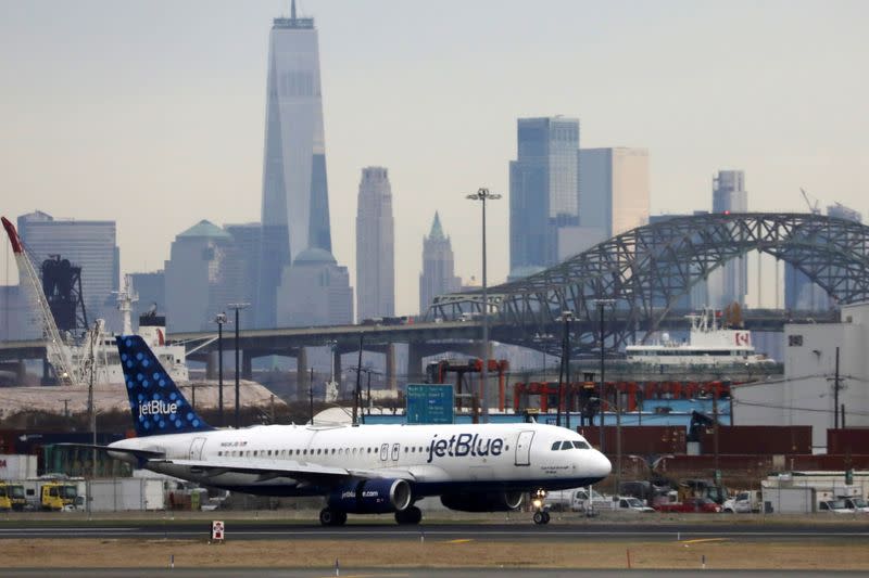 FILE PHOTO: A JetBlue passenger jet lands with New York City as a backdrop