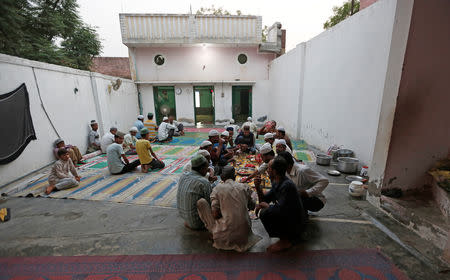 Muslims eat their Iftar (breaking of fast) meal during the holy month of Ramadan inside a madrasa that also acts as a mosque in village Nayabans in the northern state of Uttar Pradesh, India May 9, 2019. Picture taken on May 9, 2019. REUTERS/Adnan Abidi