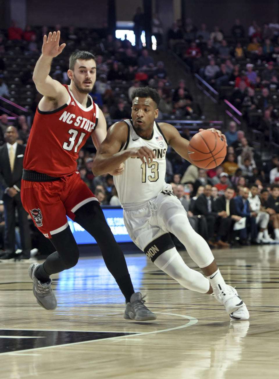 Wake Forest's Andrien White drives to the basket under pressure from N.C. State's Pat Andree in the first half of an NCAA men's basketball game, Saturday, Dec. 7, 2019 at Joel Coliseum in Winston-Salem, N.C. (Walt Unks/Winston-Salem Journal via AP)