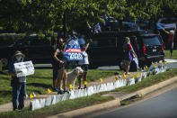 Supporters of President Donald Trump and protesters hold banners as the motorcade of President Trump enters the Trump National Golf Club in Sterling, Va., Sunday, Aug. 30, 2020. (AP Photo/Manuel Balce Ceneta)