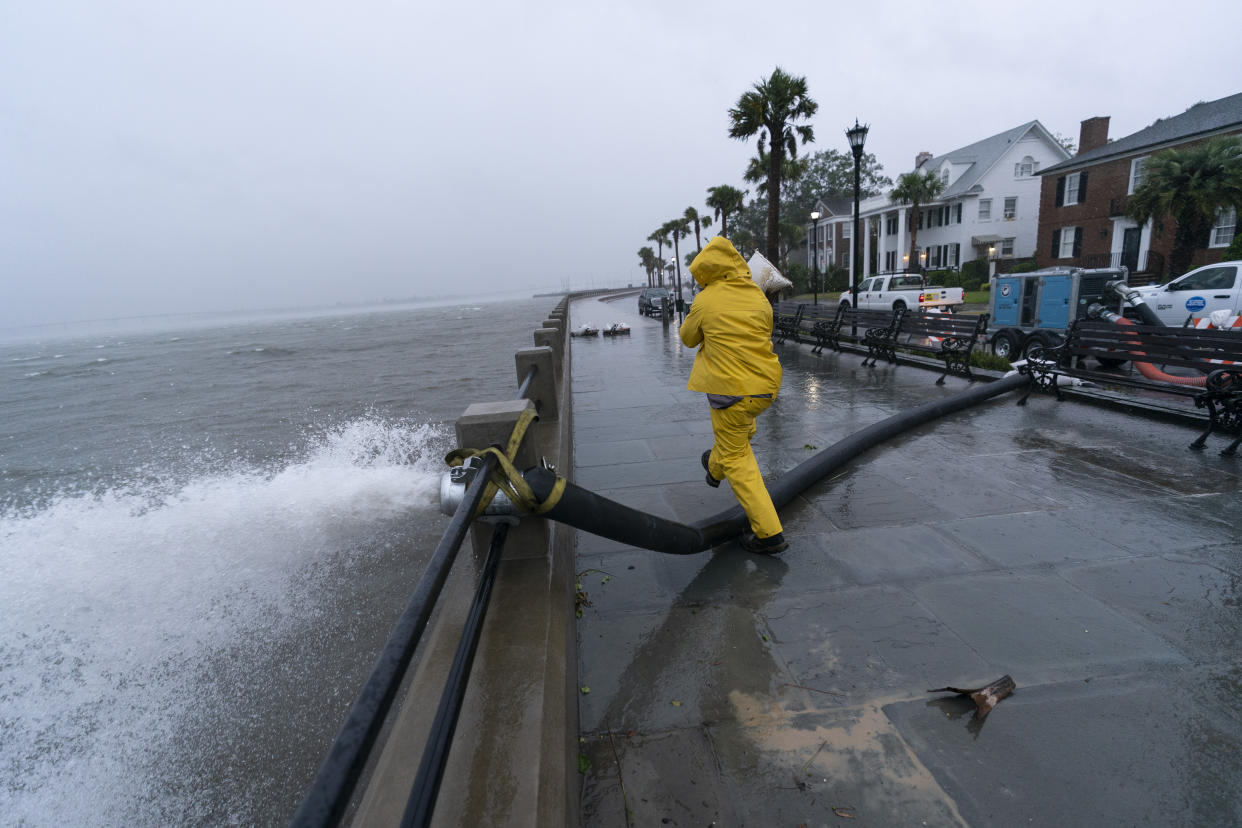A worker moves a sandbag after a pump was placed to remove water from the Battery as the effects from Hurricane Ian are felt on Friday in Charleston, S.C. 
