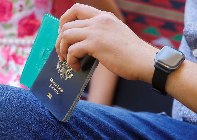 Palestinian American Hani Almadhoun holds his U.S. passport as he sits at home in Beit Lahiya