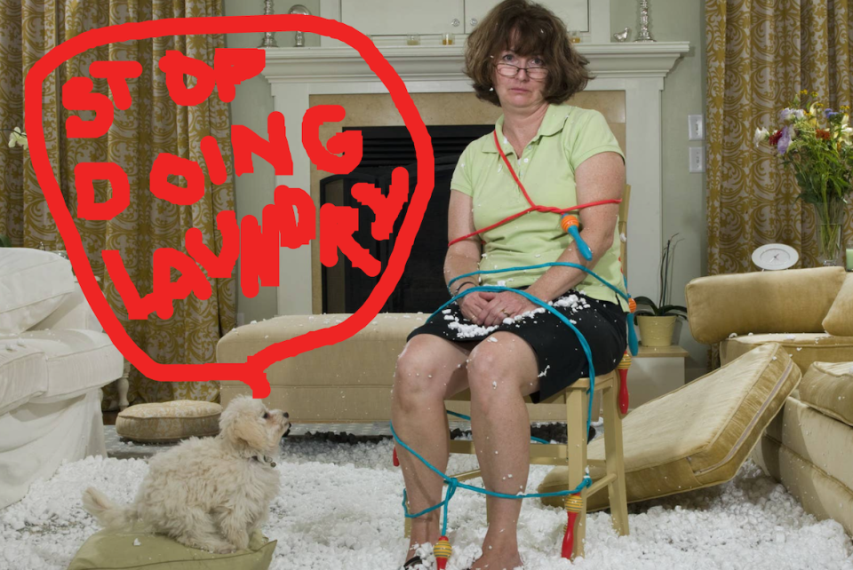 Woman sitting in a living room, tied up with a jump rope, with stuffing from her sofa cushions all over the floor, and a little dog looking at her with a comment bubble above it: "Stop doing laundry"