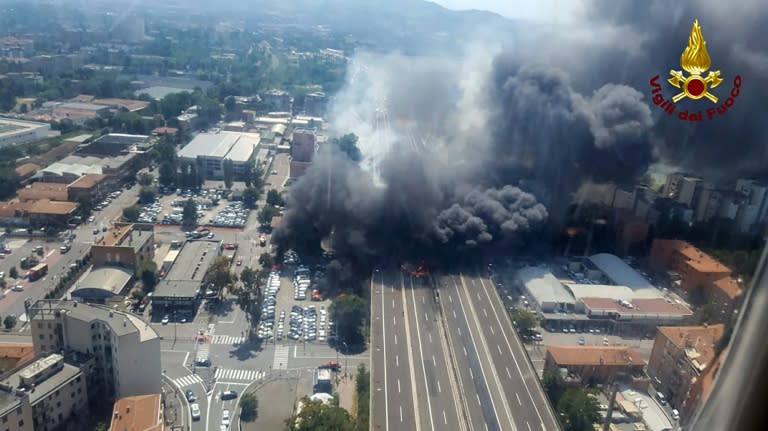 This handout picture taken from an helicopter and released by the Vigili del Fuoco, the Italian firement, on August 6, 2018, shows black smoke rising in the sky after a tanker exploded on the motorway close to the airport, in Bologna