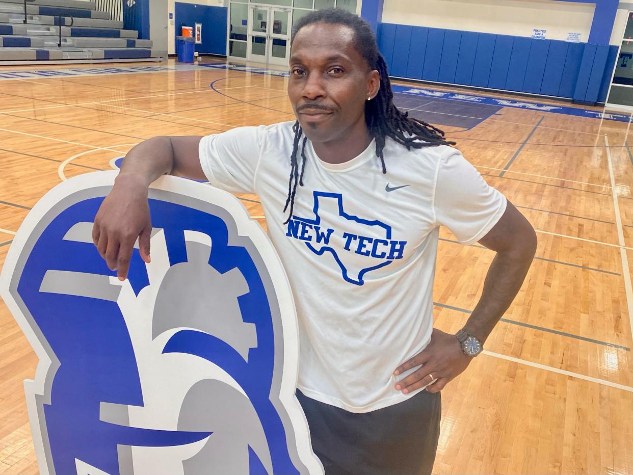 Manor New Tech head coach Derrick Lewis, displaying the Titans logo in the school gym, led LASA to a winning record last year after going 2-8 in 2022. He played wide receiver for three NFL teams and took over at New Tech earlier this year.