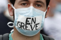 An hospital worker wears a face mask writing « In strike » during a demonstration, Tuesday, June 16, 2020 in Paris. French hospital workers and others are protesting in cities around the country to demand better pay and more investment in France's public hospital system, which is considered among the world's best but struggled to handle a flux of virus patients after years of cost cuts. France has seen nearly 30,000 virus deaths. (AP Photo/Thibault Camus)