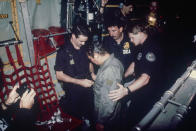 <p>Manuel Noriega watches as U.S. Drug Enforcement Agents place chains around his waist aboard a C-130 transport plane, Jan. 4, 1990. (AP Photo) </p>