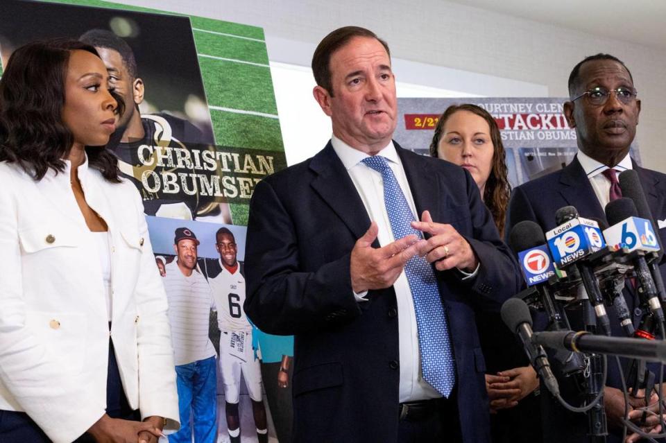 El abogado Michael Haggard (centro) habla con los medios de comunicación sobre la audiencia en a Courtney Clenney, quien admitió haber matado a Obumseli y alegó defensa propia, mientras el abogado Larry Handfield, a la derecha, y Karen Egbuna, prima de Christian Obumseli (derecha), observan durante una conferencia de prensa en el bufete de abogados Haggard en Coral Gables, Florida, el martes 9 de mayo de 2023. Daniel Varela dvarela@miamiherald.com
