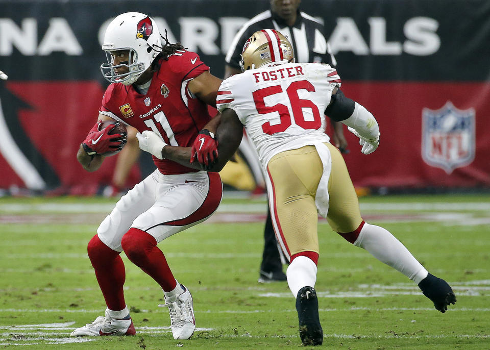 Arizona Cardinals wide receiver Larry Fitzgerald (11) is hit by San Francisco 49ers linebacker Reuben Foster (56) during the first half of an NFL football game, Sunday, Oct. 28, 2018, in Glendale, Ariz. (AP Photo/Rick Scuteri)