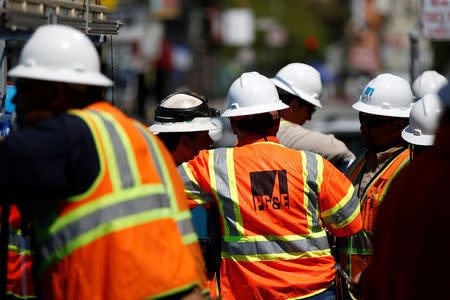 Workers with Pacific Gas and Electric (PG&E) gather outside a substation after a fire in San Francisco, California, U.S., April 21, 2017. REUTERS/Stephen Lam