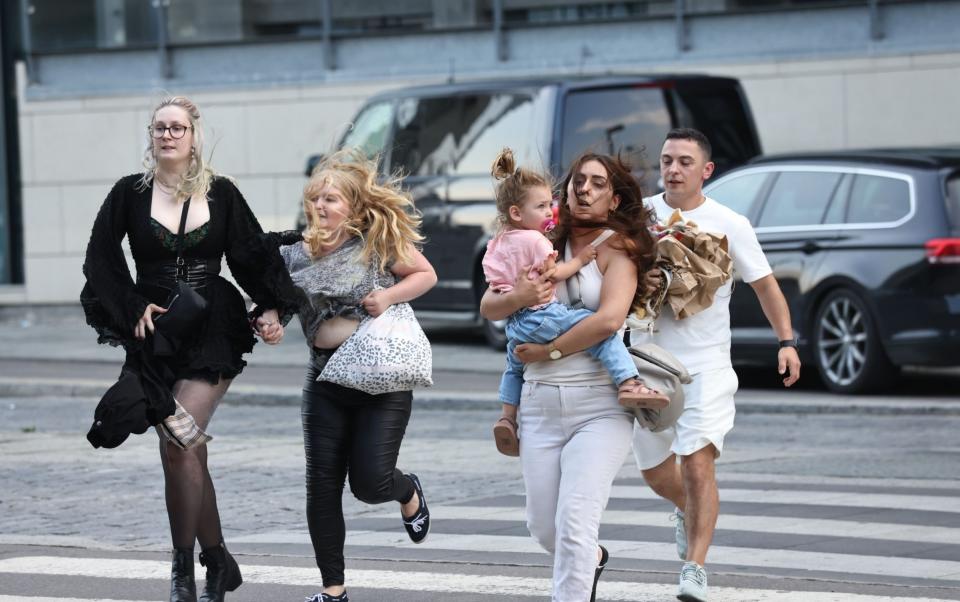 People flee the Fields shopping centre during evacuation by armed police - Olafur Steinar Gestsson/EPA-EFE/Shutterstock