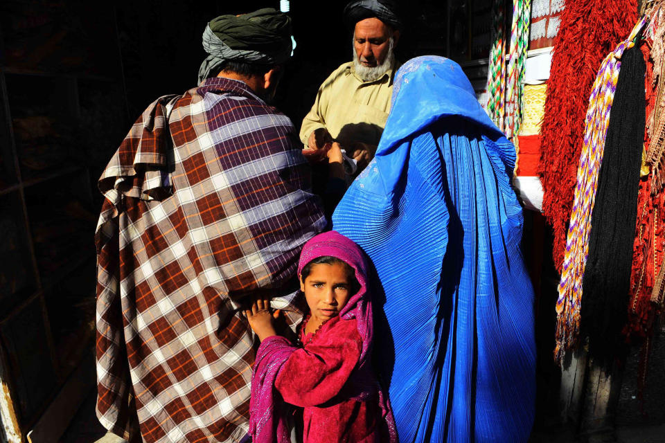 Image: An Afghan girl looks on as her parents shop in a market in Herat ahead of the Muslim feast of Eid al-Adha. (Aref Karimi / AFP - Getty Images file)