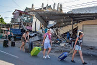 <p>Foreign tourists pull their suitcases as they walk past damaged buildings following a strong earthquake in Pemenang, North Lombok, Indonesia, Aug. 6, 2018. (Photo: Antara Foto/Ahmad Subaidi via Reuters) </p>