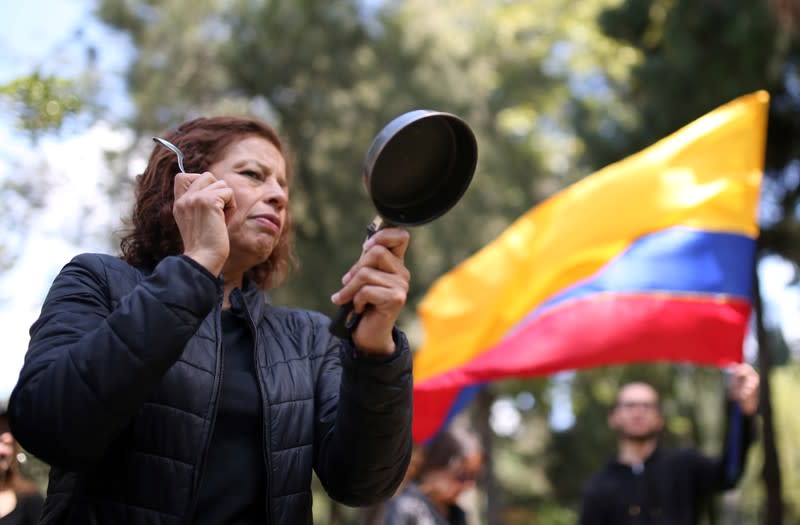 A demonstrator bangs a pan during a protest in National Park as national strike continues in Bogota