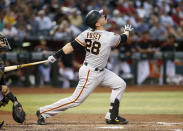 FILE - In this Friday, May 17, 2019, file photo, San Francisco Giants' Buster Posey watches the flight of his fly ball against the Arizona Diamondbacks during the third inning of a baseball game, in Phoenix. Posey is the latest big-name player to skip this season because of concerns over the coronavirus pandemic. Posey announced his decision on Friday, July 10, 2020. He says his family finalized the adoption of identical twin girls this week. The babies were born prematurely and Posey said after consultations with his wife and doctor he decided to opt out of the season.(AP Photo/Ralph Freso, File)