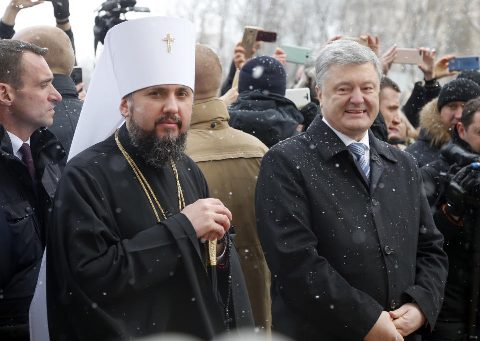 Metropolitan Epiphanius, the head of the independent Ukrainian Orthodox Church, left, and Ukrainian President Petro Poroshenko react with believers after the service marking Orthodox Christmas and celebrating the independence of the Ukrainian Orthodox Church out of the St. Sophia Cathedral in Kiev, Ukraine, Monday, Jan. 7, 2019. (AP Photo/Efrem Lukatsky)