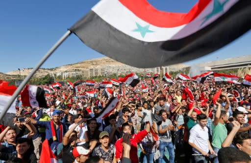 Syrians cheer on their national football team from the Umayyad Square in Damascus as they watch a broadcast of the World Cup qualifying play-off football match between Syria and Australia on October 10, 2017