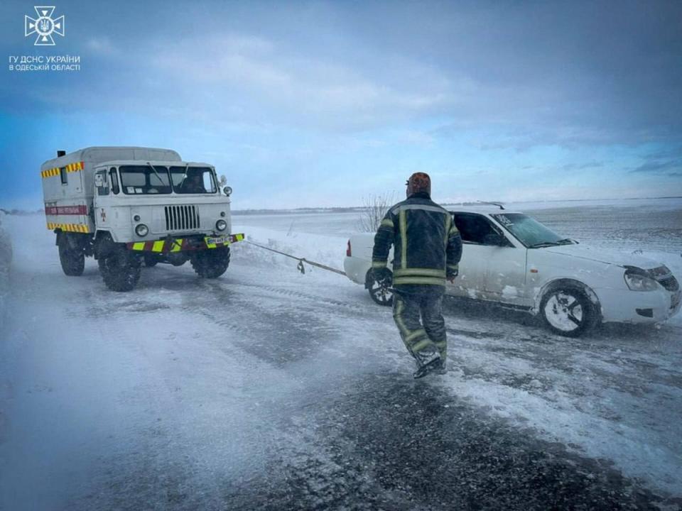 Emergency workers release a car stuck in snow in the Odesa region of Ukraine on Tuesday (via Reuters)