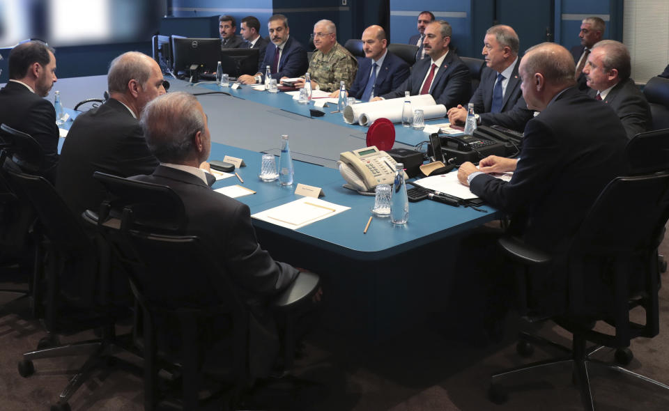 Turkey's President Recep Tayyip Erdogan, second right, with military and Intelligence chiefs, ministers and his ruling party members in an operation room at the presidential palace, in Ankara, Turkey, Wednesday, Oct. 9, 2019. Turkey launched a military operation Wednesday against Kurdish fighters in northeastern Syria after U.S. forces pulled back from the area, with a series of airstrikes hitting a town on Syria's northern border. (Turkish Presidency Press Service via AP, Pool)