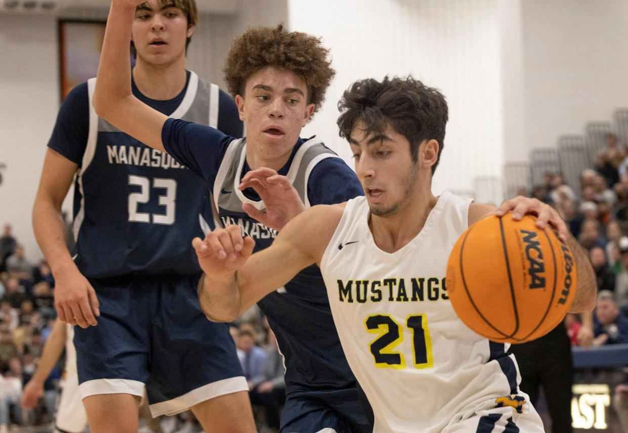 Marlboro Jonathan Spatola (No. 21) drives to the basket as Manasquan's Darius Adams (No. 1) gives chase and Manasquan's Alex Konov (No. 23) is in the background. Marlboro Boys Basketball defeats Manasquan 63-46 in Shore Conference Finals in Toms River on February 27, 2022.