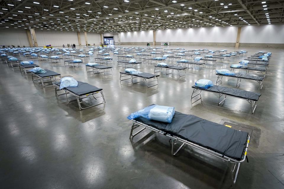 Cots are staged as members of the Texas Army National Guard set up a field hospital in response to the new coronavirus crisis at the Kay Bailey Hutchison Convention Center on Tuesday, March 31, 2020, in Dallas. (Smiley N. Pool/The Dallas Morning News via AP, Pool)