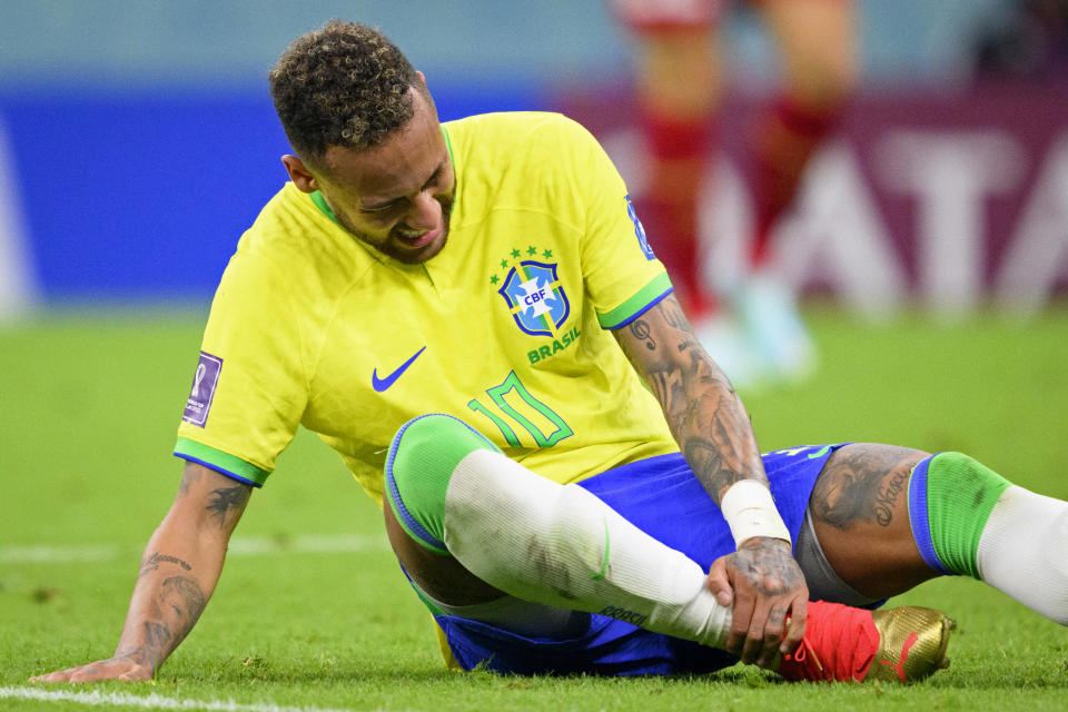 Brazil's Neymar grabs his ankle after an injury during the World Cup group G soccer match between Brazil and Serbia, at the the Lusail Stadium in Lusail, Qatar on Thursday, Nov. 24, 2022. (Laurent Gillieron/Keystone via AP)