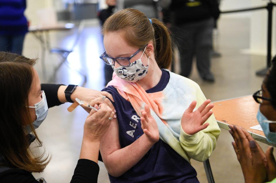 Cassie Cabe, 13, claps after receiving her booster shot from Mary Horner during a COVID-19 vaccine clinic at the Jacob Building at Chilhowee Park in Knoxville, Tenn., on Saturday, Jan. 8, 2022.